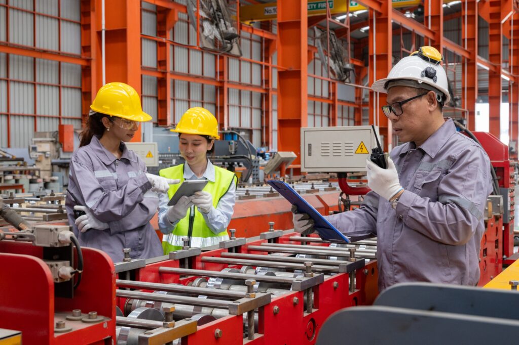 Engineers discussing machinery in manufacturing plant